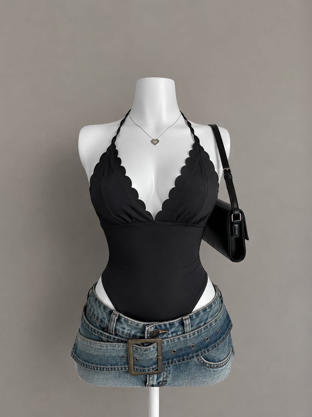 Black halter neck bodysuit with scallop edge neckline on mannequin