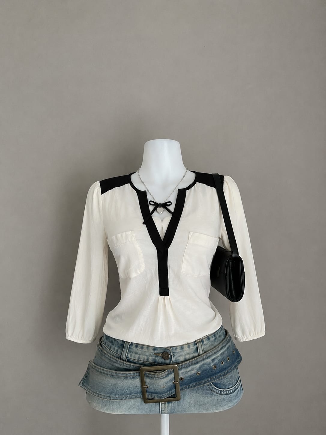 Cream black trim long sleeve top on mannequin